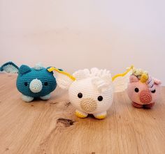 three crocheted animals sitting on top of a wooden table