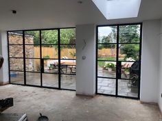 an empty room with sliding glass doors leading into the back yard and outdoor dining area