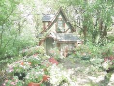 a small house surrounded by flowers and trees