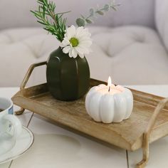 a tray with a candle and some flowers on it