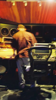 a man standing in front of a table with some food on it and speakers behind him