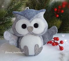 an owl ornament sitting next to a christmas tree