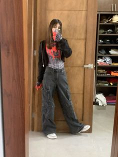 a woman standing in front of a closet taking a selfie with her cell phone