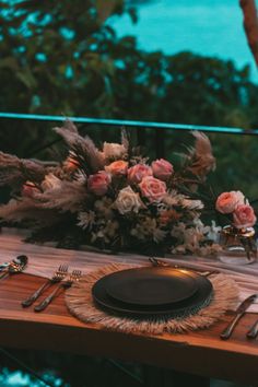 the table is set with silverware and flowers on it, along with an empty plate