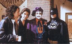 three men in costumes standing next to each other with one man wearing a batman mask