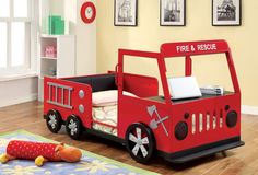 Sometimes your active little one seems to be on fire with endless energy. This metal twin fire truck bed lets the excitement of fire trucks become part of daily life. The bed features a front hood that doubles as a table and shelf, a vibrant red and black finish with silver accent trim, wheels and decorative firefighting motifs like ladders and axes, a padded faux leather headboard and a rear storage compartment. A sturdy metal construction will be ensuring fun times for years to come. Furniture of America Goodenow Red, Black, Silver Twin Metal Platform Bed with Storage | IDF-7767 Fire Truck Bed, Firetruck Bed, Twin Car Bed, Metal Twin Bed, Twin Car, Bed Shelves, Red Bedding, Car Bed, Kids Beds