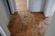 an open door leading to another room with wood flooring and white trim on the walls