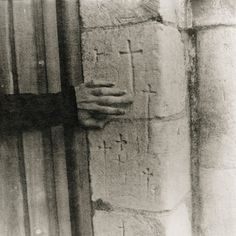 a person holding their hand on the side of a building