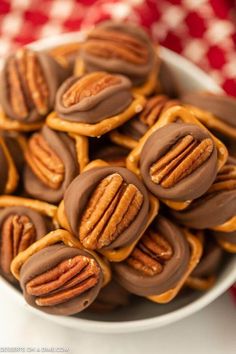 chocolate covered pretzels in a white bowl on a red and white tablecloth