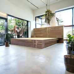 a large bed sitting in the middle of a room with lots of plants on it