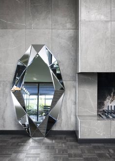 a mirror sitting on the side of a wall next to a fireplace