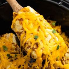 a slow cooker filled with chicken covered in cheese