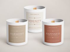 three candles with labels on them sitting next to each other in front of a white background