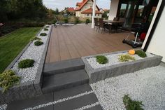 an outdoor patio with steps leading up to the deck and dining room in the background