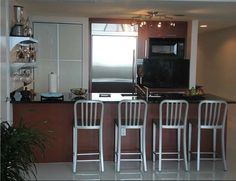 three chairs are sitting in front of the kitchen counter