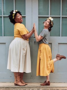 two women standing next to each other holding hands