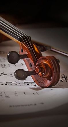 an old violin laying on top of sheet music