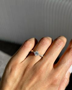 a woman's hand with a diamond ring on it