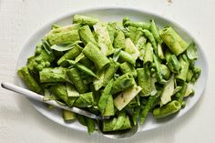 a white plate topped with green vegetables on top of a table