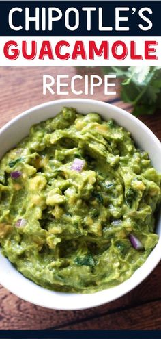 a white bowl filled with guacamole on top of a wooden table next to cilantro