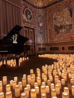 many lit candles in front of a grand piano