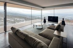 a living room filled with furniture next to a large window covered in lots of windows