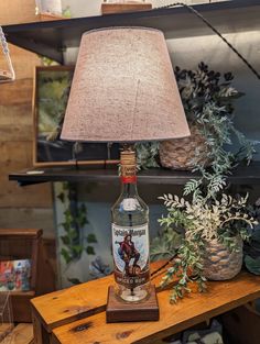 a lamp that is sitting on top of a table next to a bottle of liquor