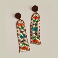 I made these Fringe Earrings using high quality Japanese glass beads. They're colorful statement earrings, light and comfortable to wear. The colors are; orange, green, silverlined brown, metallic cream and dark turquoise. Hand woven using nylon and polyester thread. Stud part is wood and stainless steel. 𑁍 Please remember to take of your earrings when showering or swimming. Dimensions of one earring: Total length of the earring: 9.5 cm / 3.74" Length of beaded part: 7.6 cm / 2.99"  Width: 2.0 Vintage White Earrings For Festive Occasion, Festive White Earrings With Colorful Beads, Vintage Multicolor Beaded Earrings With Ear Wire, Tulips And Butterflies, Stitch Jewelry, Beaded Earrings Diy, Seed Beading, Seed Bead Patterns, Bead Weaving Patterns