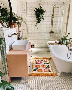 a bath room with a tub a sink and a rug