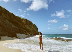 two people standing in the water on a beach