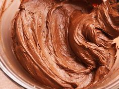 a bowl filled with chocolate frosting on top of a counter