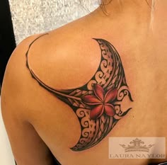 the back of a woman's shoulder with a flower and crescent tattoo on it