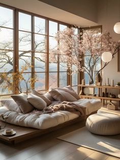 a living room filled with lots of furniture and large windows overlooking the trees in the distance