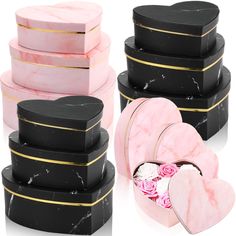 four heart shaped boxes with pink roses in them and one black box with gold trim