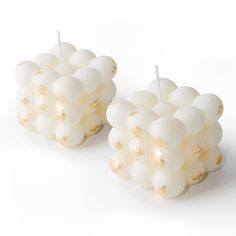 two white candles sitting on top of each other