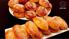 two white plates filled with pastries on top of a black tablecloth covered table