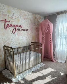 a baby's crib in front of a floral wallpapered nursery room