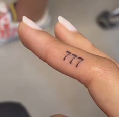 a person with a small tattoo on their left hand and the number seven in hebrew