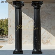 two black marble pillars in front of a building