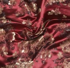 a red and gold flowered fabric with metallic foil on the bottom, it is very soft