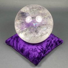 a crystal ball sitting on top of a purple pillow