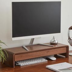 a computer monitor sitting on top of a wooden desk next to a keyboard and mouse