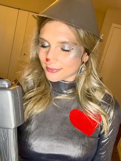 a woman wearing a silver outfit with a red heart on it's chest and nose