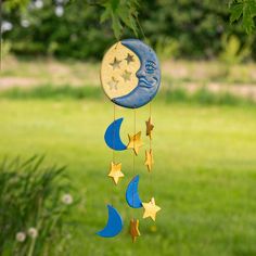 a wind chime hanging from a tree with stars and the moon on it's side