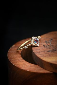 a close up of a ring on top of a wooden stand with a black background