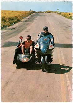 two people riding on the back of a motorcycle with a side car attached to it