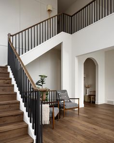 a living room filled with furniture and a stair case next to a bannister