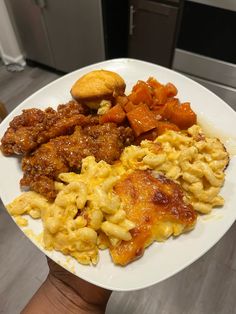 a white plate topped with macaroni and cheese covered in meat