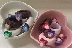 two bowls filled with hearts and chocolates on top of a white counter next to each other