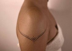 a woman's shoulder with a small tattoo on the left side of her arm